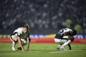 O Corinthians vive um dos seus momentos mais críticos na história recente. Com apenas quatro vitórias em 24 rodadas do Campeonato Brasileiro, o clube paulista se encontra em uma situação alarmante, com 70,9% de probabilidade de rebaixamento para a Série B, segundo projeções estatísticas. A cada rodada que passa, a sombra do descenso se torna mais real e assombra a torcida corintiana. Além do risco iminente de cair para a segunda divisão, as chances do Timão de disputar competições internacionais na próxima temporada são praticamente nulas. A probabilidade de conquistar o título brasileiro ou de garantir uma vaga na Libertadores é ínfima, enquanto a possibilidade de disputar a Sul-Americana se limita a apenas 2,1%. A análise dos pontos perdidos revela um quadro ainda mais preocupante. O Corinthians ocupa a penúltima posição nesse quesito, demonstrando um desempenho inferior aos seus principais concorrentes. A equipe paulista precisa urgentemente melhorar seu rendimento para escapar da zona de rebaixamento. O Cuiabá, com duas partidas a menos, está apenas quatro pontos atrás do Corinthians e possui 80% de chance de queda. O Atlético-GO, com 87% de probabilidade de rebaixamento, também pressiona o Timão. À frente do Corinthians, o Vitória, com os mesmos 22 pontos em 24 partidas, divide a penúltima posição com o clube paulista, evidenciando a disputa acirrada na zona de descenso. Fluminense (24 pontos) e Criciúma (25 pontos) também se encontram próximos da zona de rebaixamento, com 39,5% e 38% de probabilidade, respectivamente. A situação do Corinthians se torna ainda mais delicada quando se considera o calendário de jogos. Após enfrentar o Juventude pelas quartas de final da Copa do Brasil, o Timão terá um desafio ainda maior no domingo (1º): receber o Flamengo pela 25ª rodada do Brasileirão. A apenas quatro pontos do Corinthians, o Cuiabá e o Atlético-GO pressionam a equipe alvinegra, que precisa urgentemente de uma vitória para se afastar da zona de rebaixamento e acender a esperança de permanência na Série A. O modelo estatístico utilizado para calcular as probabilidades de rebaixamento foi desenvolvido por um time do Departamento de Estatística da USP e testado desde a Copa do Mundo de 1998. Os dados apresentados indicam um cenário bastante desafiador para o Corinthians, que precisa de uma reação imediata para evitar o pior. A torcida corintiana vive momentos de angústia e incerteza, enquanto a diretoria e a comissão técnica buscam soluções para tirar o clube da crise. A próxima partida contra o Flamengo será um verdadeiro teste de fogo para o Corinthians. Uma vitória pode dar um novo ânimo à equipe e aproximá-la da zona de segurança. No entanto, um tropeço pode aprofundar ainda mais a crise e colocar o clube em uma situação ainda mais delicada. A permanência do Corinthians na Série A depende de uma série de fatores, como a recuperação da equipe, a melhora do desempenho individual dos jogadores e a capacidade de superar a pressão. A torcida corintiana, por sua vez, espera que o time encontre forças para reagir e sair dessa situação difícil.